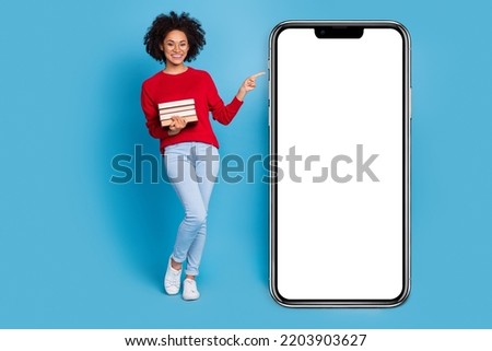 Photo of adorable smart young lady dressed red pullover holding book empty space isolated blue color background