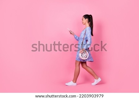 Full size body photo of young happy confident lady holding phone white bag reading blog isolated on pink color background