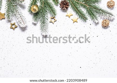 Festive Christmas and New Year border with fir tree branches and golden decorations on white marble background with copy space for your design.