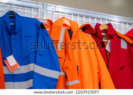 Jackets with reflective stripes - road workers special clothing. Workwear, protection clothing and outfit concept Royalty-Free Stock Photo #2203923097