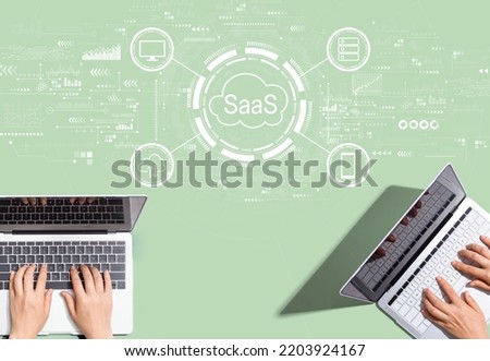 SaaS - software as a service concept with people working together with laptop computers