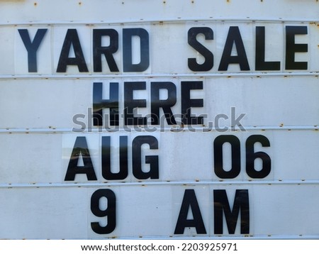 A sign indicating that a yard sale is taking place with the time and date.
