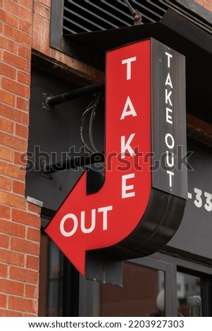 Take out red sign with arrow on a building near fast food restaurant or cafe