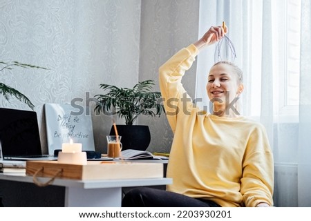 Woman on workplace with Head Massager Scalp Scratcher with Fingers. Self-massage with Head Scratcher Tingler Scalp for reduce Stress and for Hair Growth and Body Deep Relaxation Royalty-Free Stock Photo #2203930201