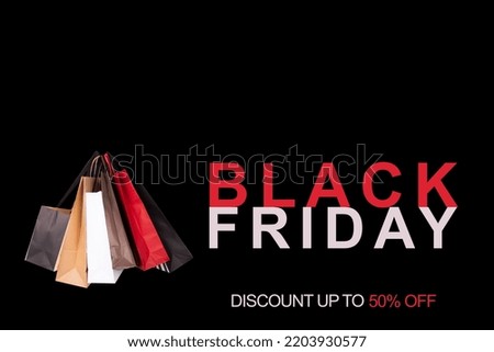 Black Friday Discount up to 50% off Sign and bags in a black background
