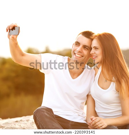 Loving couple taking selfie in the park