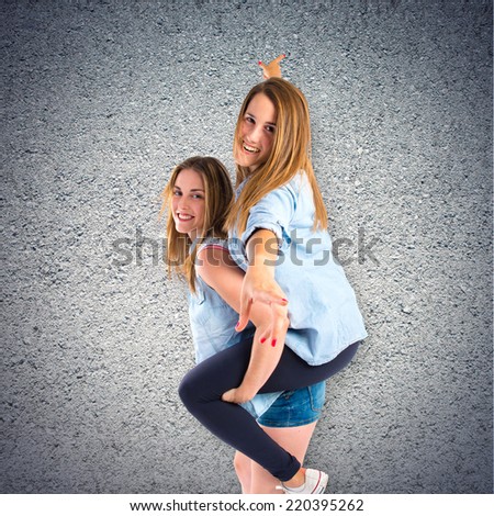Sisters playing over textured background 