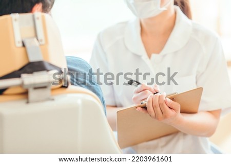 Asian female nurse and patient (dentist) Royalty-Free Stock Photo #2203961601