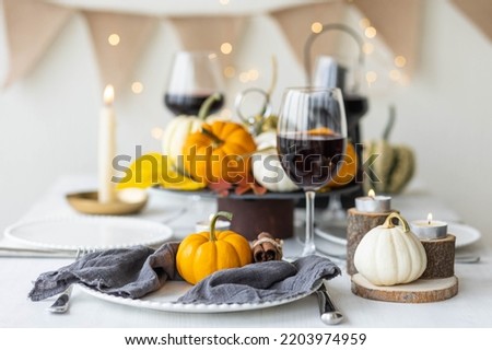Idea for a beautiful autumn setting for thanksgiving or halloween family dinner or wedding. Orange pumpkin as decor. Cozy fall home atmosphere.