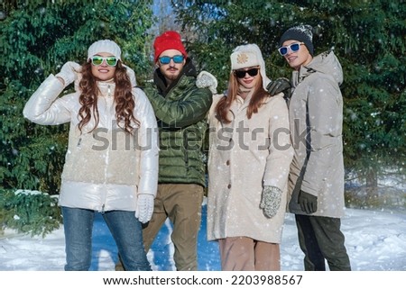 Outdoor winter activities. Happy friends guys and girls have an active rest and rejoice in a winter park on a sunny day. Winter fashion. Good mood, emotions. 