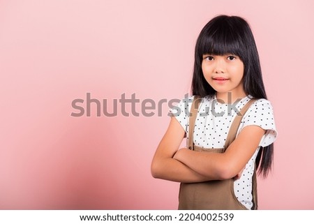 Asian little kid 10 years old smiling with arms crossed at studio shot isolated on pink background, Portrait of Happy confidence child girl lifestyle, Positive person Royalty-Free Stock Photo #2204002539
