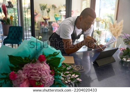 Florist makes calculations in a flower shop