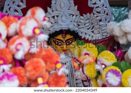 Beautifully decorated Durga idol face with use of selective focus on a particular part of the face, with rest of the face and everything else blurred.