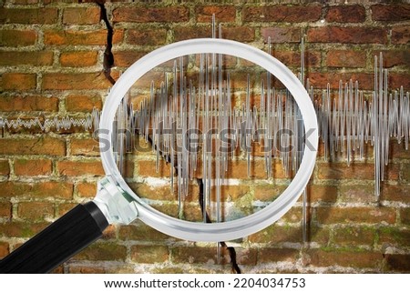 Earthquake wave graph concept with cracked and damaged brick wall and magnifying glass Royalty-Free Stock Photo #2204034753