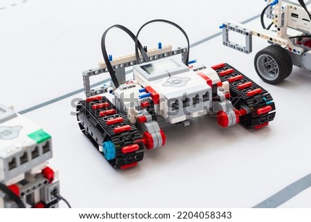Building model RC robots concept. Caterpillar model of radio-controlled self-propelled vehicle.Radio control robot assembly on white desk. Professional toy RC models of robots. Natural lighting. Royalty-Free Stock Photo #2204058343