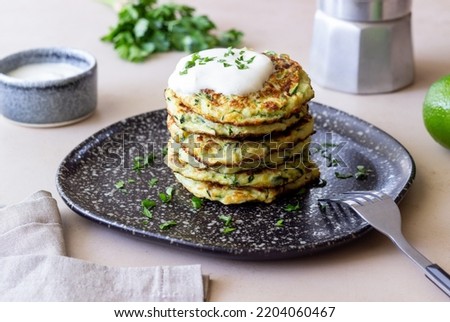 Zucchini fritters or pancakes with sour cream and herbs. Healthy eating. Vegetarian food Royalty-Free Stock Photo #2204060467