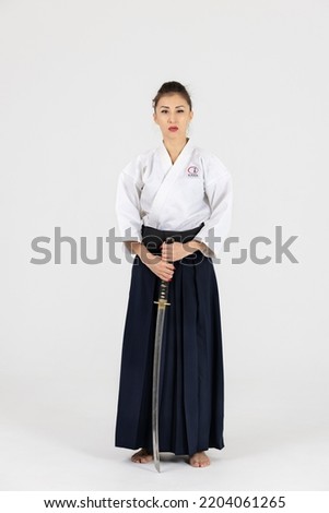 Aikido master woman in traditional samurai hakama kimono with black belt with sword, katana on white background. Healthy lifestyle and sports concept. Royalty-Free Stock Photo #2204061265