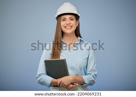 Woman architect holding book standing against blue background. Royalty-Free Stock Photo #2204069231