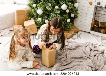 two little girls Sharing a Surprise on Christmas Morning