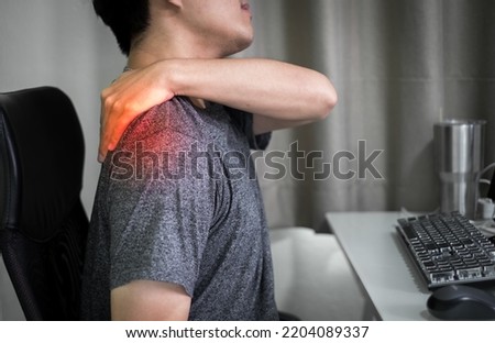 Asian man used hand touching neck and shoulder feeling body pain, office syndrome, work from home a long time, importance of healthy spinal backbone, physical therapy concept Royalty-Free Stock Photo #2204089337