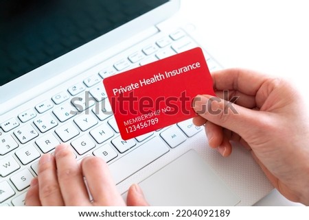 Close-up of woman holding a private health insurance card with laptop concept Royalty-Free Stock Photo #2204092189