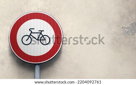 Round bicycle sign transit prohibited for bicycles on a building grey wall exterior background. Bicyle road sign, prohibition red sign, copy space. 