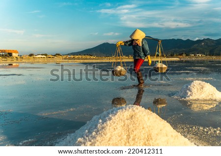 Nha Trang, Vietnam. Women carry salt from salt farm to factory.