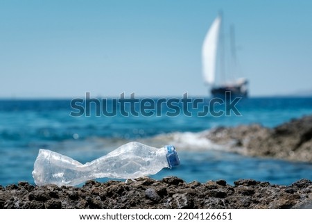Trash, plastic, garbage, bottle, environmental pollution on the beach of people. High-quality free stock photo image of trash, plastic bottle on the rock. Waste that polluted the ocean environment