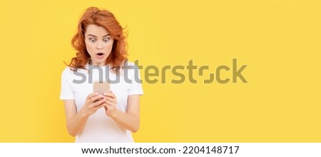 Woman surprised with smartphone on yellow background. Woman isolated face portrait, banner with mock up copy space. Royalty-Free Stock Photo #2204148717