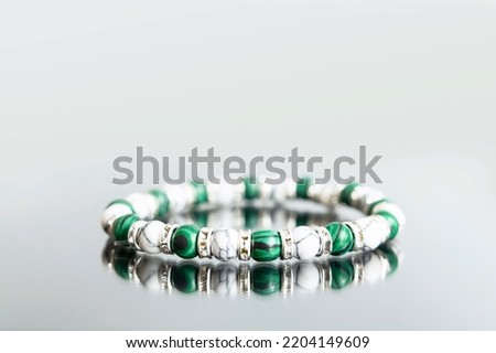 Bracelet made of natural jasper stones beads isolated on white background. Handmade jewelry. Woman exoteric accessories. Talismans and amulets. Selective focus