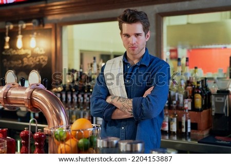 Portrait of caucasian young bartender at work 