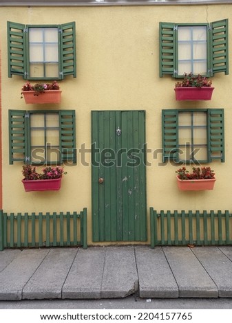 Yellow tiny house with green door and green window
