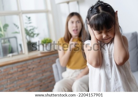 Portrait of Asian little girl close her ear while angry mother yelling about her stubbon for Domestic Violence Concept Royalty-Free Stock Photo #2204157901