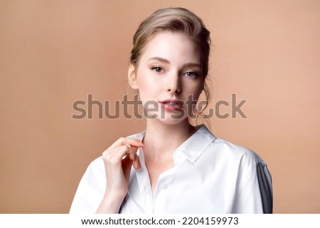 Young blond woman in a white blouse with natural makeup and glowing clear skin Royalty-Free Stock Photo #2204159973