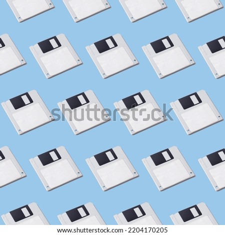 Seamless pattern of floppy disks for a computer on a blue background. Retro gadgets.