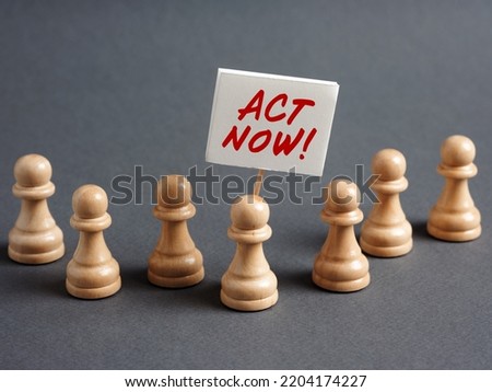 Chess pawn protester holding a sign banner with the message ACT NOW surrounded by the crowd. Take action now concept.