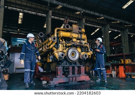 the technician repairing and inspecting the big diesel engine in the train garage Royalty-Free Stock Photo #2204182603