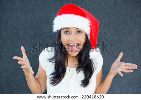 Closeup portrait of a cute Christmas woman with a red Santa Claus hat, white dress, exciting discounts, holiday shopping season, wide open mouth. Positive human emotion on isolated grey background.