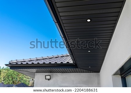 A modern graphite herringbone roof lining is attached to the trusses, visible turned on LED lights. Royalty-Free Stock Photo #2204188631