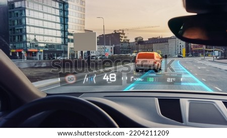 Futuristic Autonomous Self-Driving Car Moving Through City, Head-up Display Showing Infographics: Speed, Distance, Navigation. Road Scanning Concept. Driver Seat POV  First Person View FPV