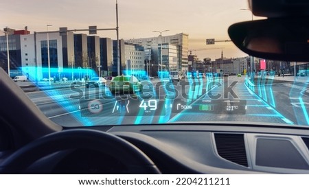 Futuristic Autonomous Self-Driving Concept Car Moving Through City, Head-up Display HUD Showing Infographics: Speed, Distance, Navigation, Fuel. Road Scanning. Driver Seat Point of View POV  FPV. Royalty-Free Stock Photo #2204211211