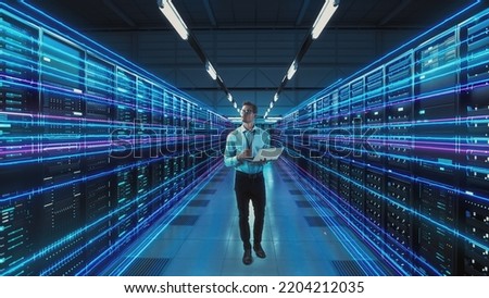 Futuristic Concept: Data Center Chief Technology Officer Holding Laptop, Standing In Warehouse, Information Digitalization Lines Streaming Through Servers. SAAS, Cloud Computing, Online Service Royalty-Free Stock Photo #2204212035