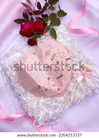 Valentine’s love shaped chocolate with gold pink and white sprinkles, decorated with roses, ribbon and smasher on pink background Royalty-Free Stock Photo #2204213337