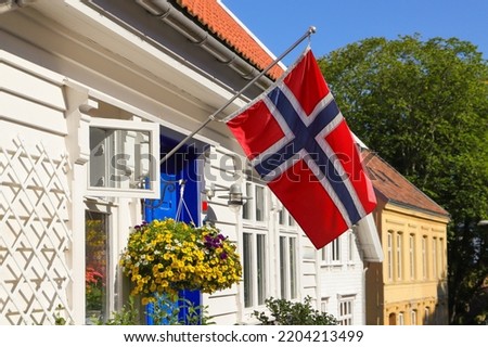A norwegian flag on a white wooden house in the old town of Stavanger, Norway Royalty-Free Stock Photo #2204213499