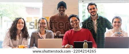Horizontal banner or header with smiling multiethnic coworkers looking at camera making team picture in modern office together - Diverse work group or department laugh posing for photo at workplace