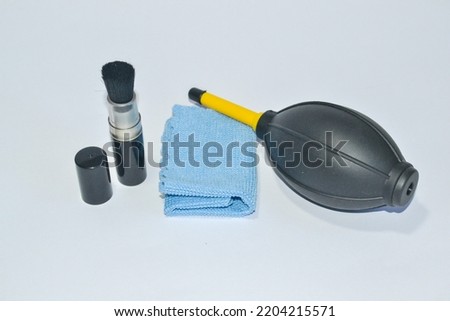 camera cleaning set consist of blower, brush, and microfiber cloth isolated on white background