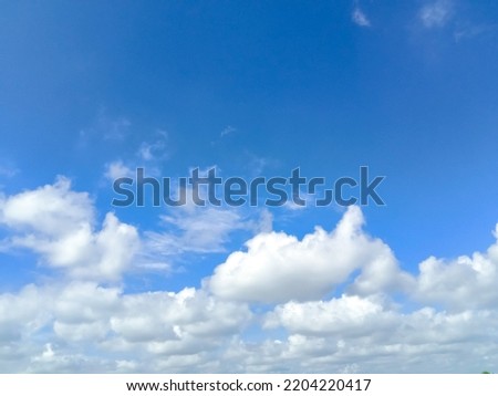 Beautiful white clouds on deep blue sky background. Elegant blue sky picture in daylight. Tiny small soft white clouds in the blue sky background. Cumulus clouds in clear blue sky. No focus