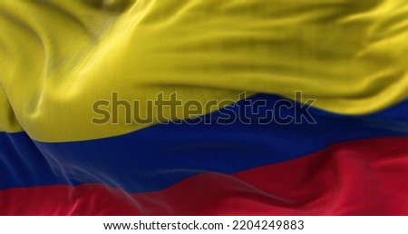 Close-up view of the Colombia national flag waving in the wind. The Republic of Colombia is a country in South America. Fabric textured background. Selective focus