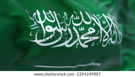 Close-up view of Saudi Arabia national flag waving in the wind. The Kingdom of Saudi Arabia (KSA) is a country on the Arabian Peninsula in Western Asia. Fabric textured background. Selective focus