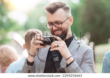 smiling male tourist looking at the screen of his camera.